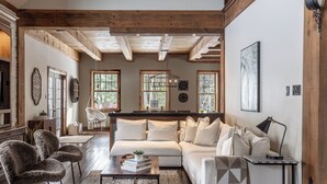 A cozy living room with a sofa, armchairs, a coffee table, and a side table with a lamp.