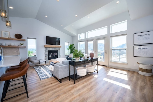 The living room boasts abundant natural light, a welcoming fireplace, and direct access to the deck.