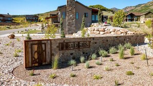 A modern residential area with a stone wall entrance labeled "BRIDGES." - Private Powder Mtn B2 | Desk| Hot Tub| Ski Retreat (Eden)
