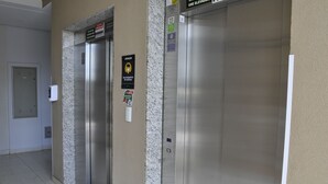 Two elevators with signs indicating elevator use and a mask requirement. - Golden Dolphin Supreme - Achei Férias (Caldas Novas)