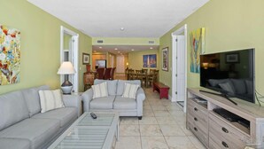 A living room with a sofa, TV, and dining area.