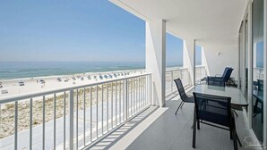 A balcony with a view of the beach and ocean.