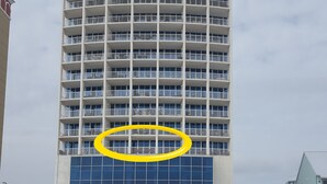 A high-rise hotel with multiple balconies and a large glass facade.