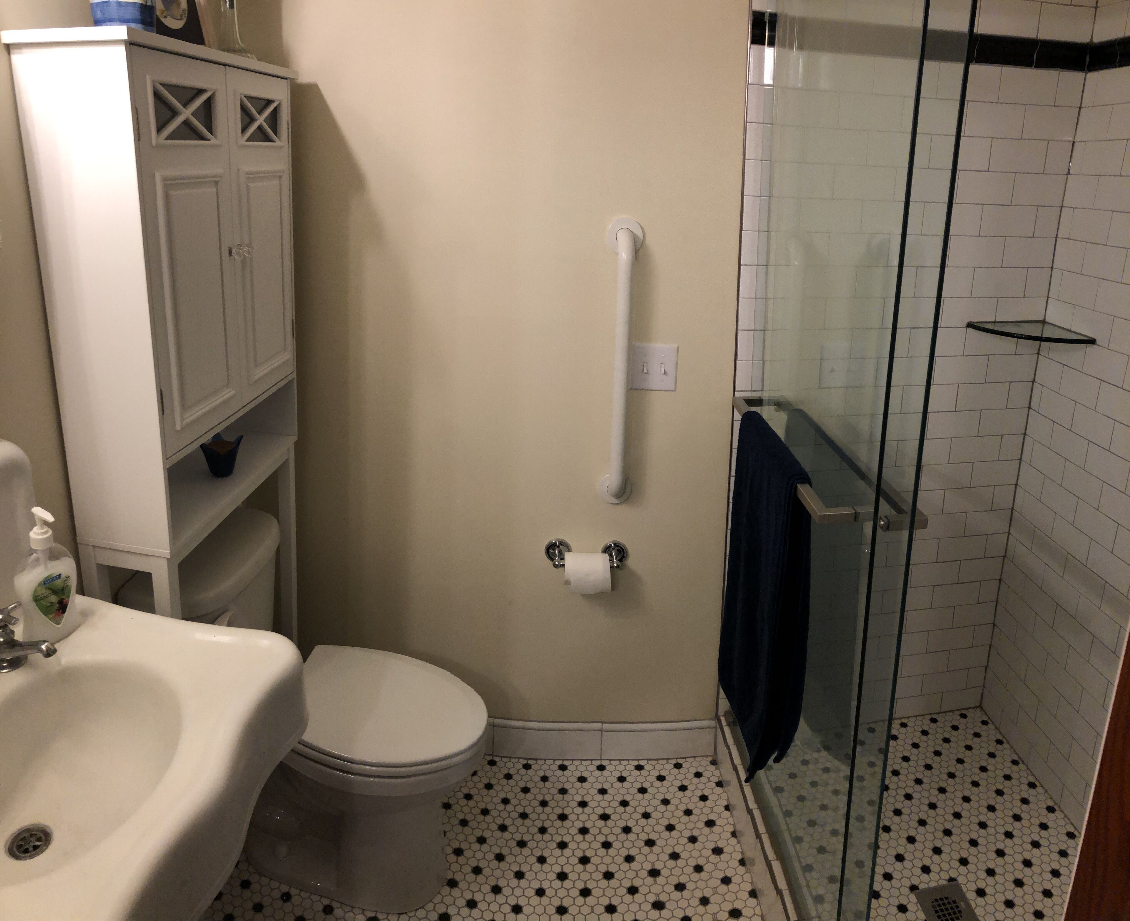 A bathroom with a toilet, sink, and shower.