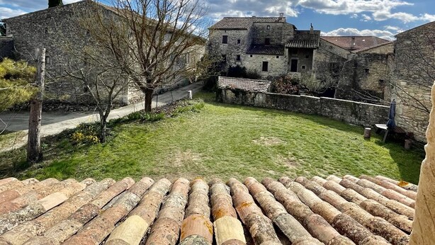 A courtyard with stone buildings, a pathway, and a view of the sky. - Cottage near Barjac (Saint-Privat-de-Champclos)