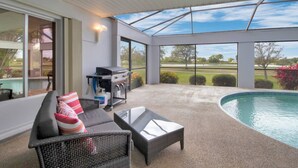 A covered outdoor area with a pool, a grill, and seating. - Feels Like Home - w/ Heated Pool Book Now! (Punta Gorda)