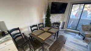 Et spiseområde med et træbord, stole og en bænk. Et juletræ ses i hjørnet.