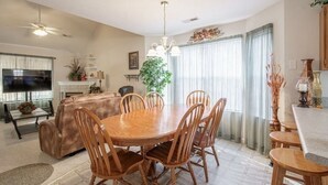 A spacious living room with a wooden dining table and chairs, a comfortable sofa, a television, and a fireplace. - Great Location! Close to Everything!
Game Room! Perfect for Family & Friends! (Pigeon Forge)
