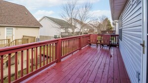 A residential deck with a red railing, a wooden staircase, and a view of neighboring houses. - Great Location! Close to Everything!
Game Room! Perfect for Family & Friends! (Pigeon Forge)