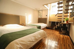 Habitación de hotel con dos camas, un escritorio, una silla, una escalera y una ventana.