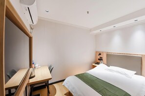 A hotel room with a bed, a desk, a chair, a nightstand, and an air conditioning unit. - Greentree Inn Hefei Fanhua Avenue Juece Building B (Hefei)