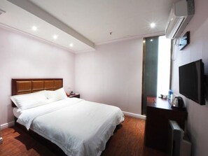 A hotel room with a large bed, a bedside table, a TV, an air conditioning unit, and a window. - Greentree Inn Hefei Fanhua Avenue Juece Building B (Hefei)