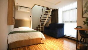 A hotel room with a bed, a desk, a chair, a staircase, and a window. - Greentree Inn Hefei Fanhua Avenue Juece Building B (Hefei)