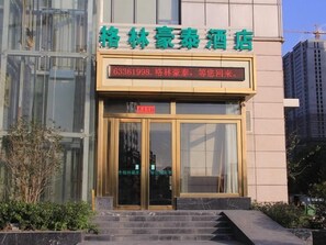 A hotel entrance with a glass door and a digital display above it. - Greentree Inn Hefei Fanhua Avenue Juece Building B (Hefei)