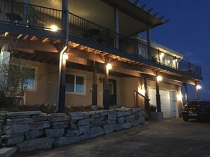 A two-story house with a stone retaining wall, a covered porch, and a garage. - awesome valley views, with all your home needs plus the “little extras” (Orem)
