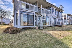 A modern two-story house with a balcony, large windows, and satellite dishes.