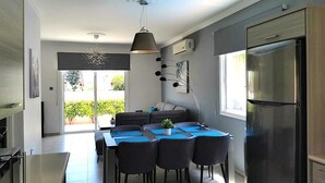 A modern kitchen with a dining area, a built-in oven, and a large refrigerator. - Villa Alba, Luxury 4 BDRM Villa with Heated Pool (Protaras)