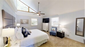Cozy retreat with a large bed, television, and dresser, perfect for a comfortable stay.