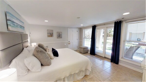 Relax in this serene bedroom with a large bed, window, and seating area.