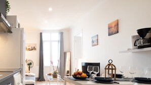 A modern kitchen with a dining area, white furniture, and a coffee machine. - Lovely & Independant - Queen size bed, netflix, wifi (Lourdes)