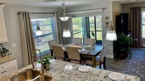 A modern kitchen with granite countertops, a stainless steel sink, and pendant lighting. - Water Front Boundary Vacation Home Villa close to beaches, golfing, Fishing (Rotonda West)