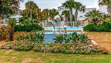 Relax by the serene pool surrounded by lush greenery and vibrant flowers.