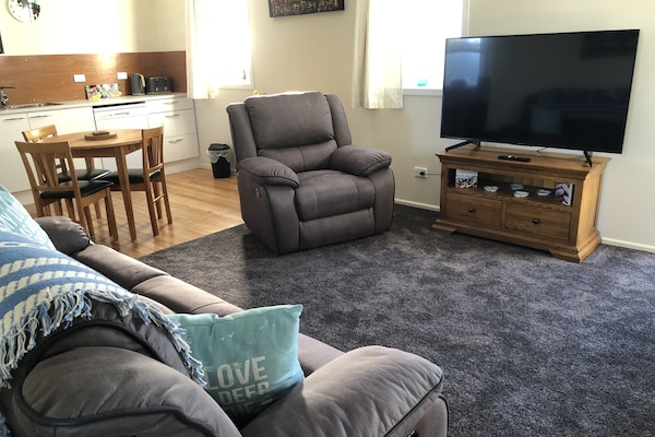 Lounge seating, 55" smart tv, looking to dining & kitchen areas.