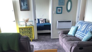 Een gezellige woonkamer met een ronde houten tafel, twee banken en een bijzettafeltje met een decoratief object.