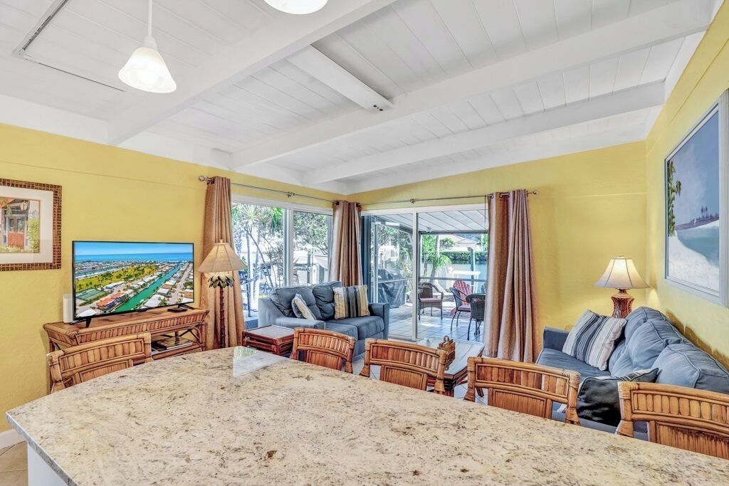 A spacious living area with a large island, comfortable seating, and a television.