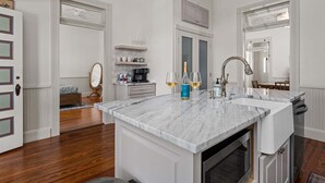 A kitchen with a marble countertop, a sink, and a coffee machine. - Morning Glory | Newly Renovated | Pet-friendly (Fredericksburg)