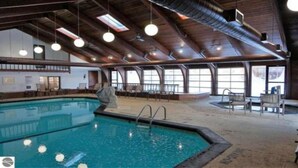 Ein Hallenbad mit Holzbalkendecke und großen Fenstern.