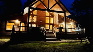 A log cabin with a large porch, multiple windows, and a staircase leading to the entrance. - Candy Apple Cabin- Stay 3 get 4th Night FREE (Broken Bow)