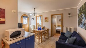 A compact living space with a kitchenette, a dining area, and a seating area.
