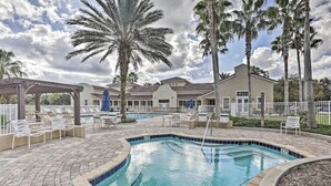 A pool area with lounge chairs, a covered seating area, and a palm tree. - Luxurious River Views, Resort Amenities, Lrg 3 Bed, 2 Bath, Corner Unit, 2100 SF (Palm Coast)