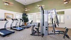 A gym with treadmills, a weight machine, and ceiling fans. - Luxurious River Views, Resort Amenities, Lrg 3 Bed, 2 Bath, Corner Unit, 2100 SF (Palm Coast)