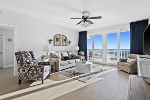 Relax in this stylish living room with a sofa, armchair, and coffee table, offering a view of the city skyline.