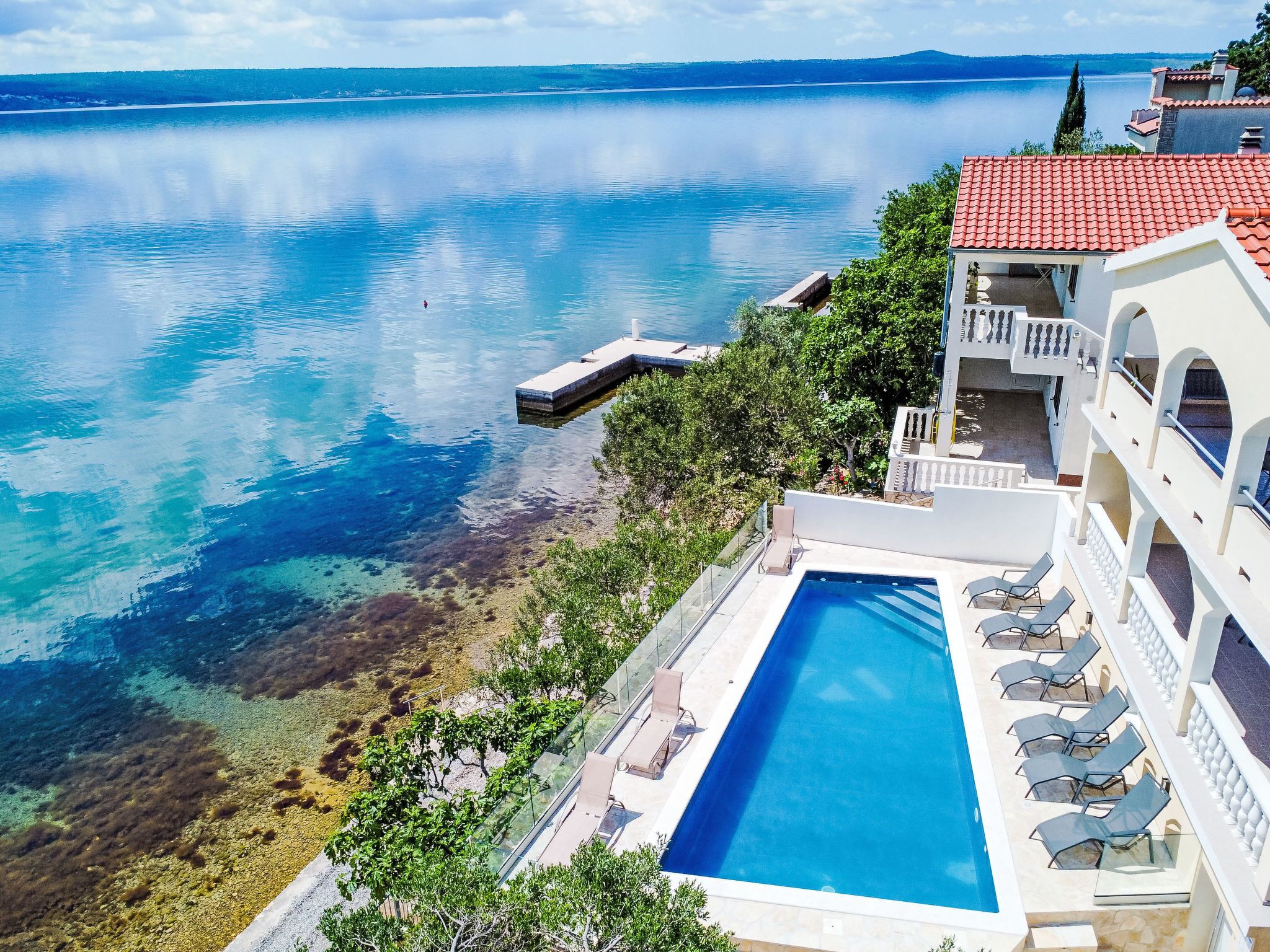 Un resort con piscina, playa y vistas al mar.