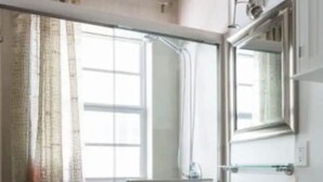 Une salle de bain avec une douche à parois de verre, un lavabo blanc et des toilettes.
