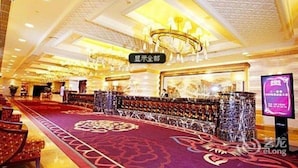 A spacious hotel lobby with a red carpet, a chandelier, and a bar area. - Shenyang Royal Wanxin Hotel (Shenyang)