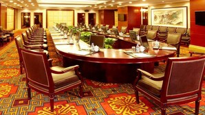 A conference room with a long table, multiple chairs, and a carpeted floor. - Shenyang Royal Wanxin Hotel (Shenyang)
