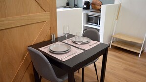 A dining area with a table set for two, a chair, and a bench.