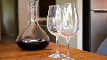 A wooden table with a wine bottle and two wine glasses.