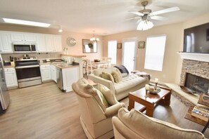 Een smart-tv, een open haard, boeken en een kantoor