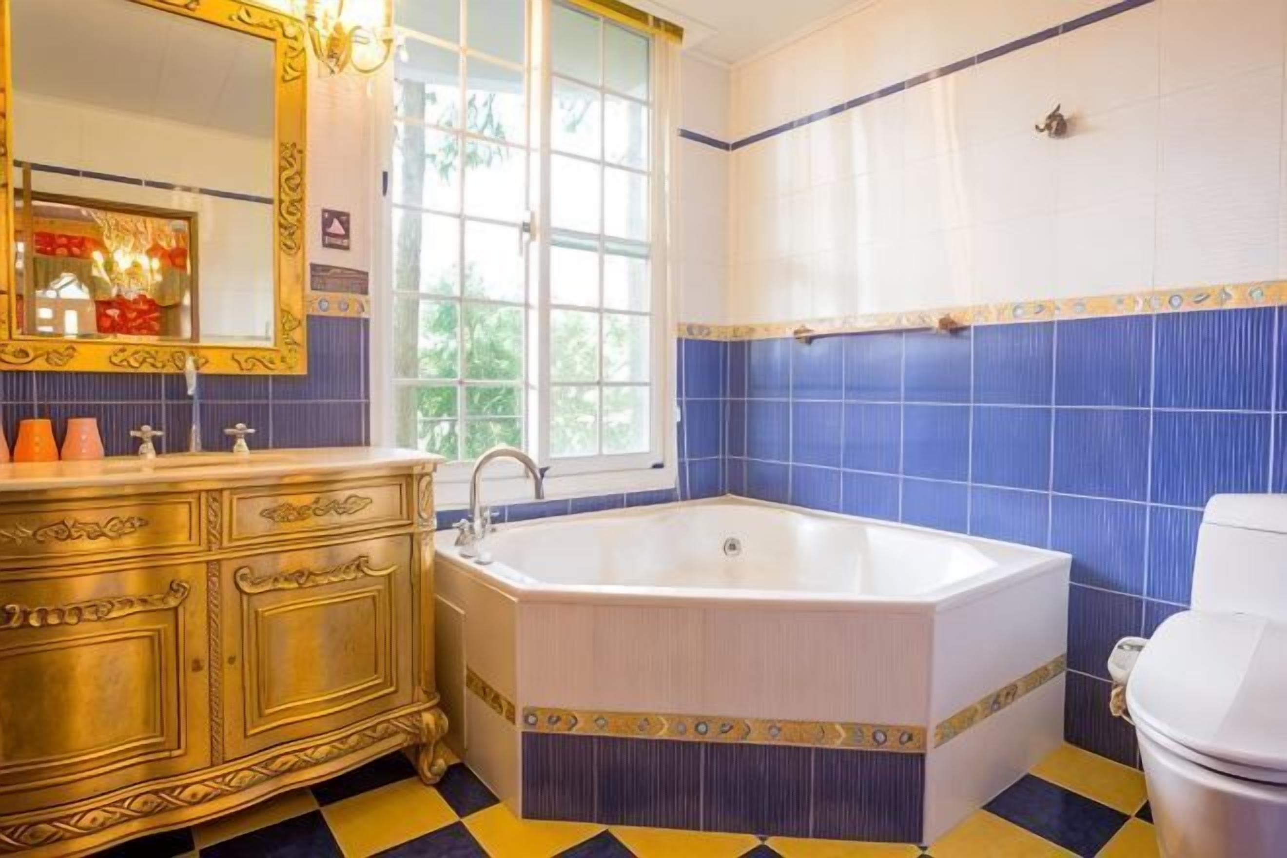Ein Badezimmer mit einer Badewanne, einem Waschtisch mit Spiegel und einer Toilette.