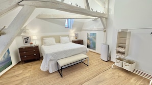 A bedroom with a bed, bedside tables, a bench, a painting, and a built-in shelf unit. - La Dolce Vita a few steps from everything Beaune has to offer (Beaune)
