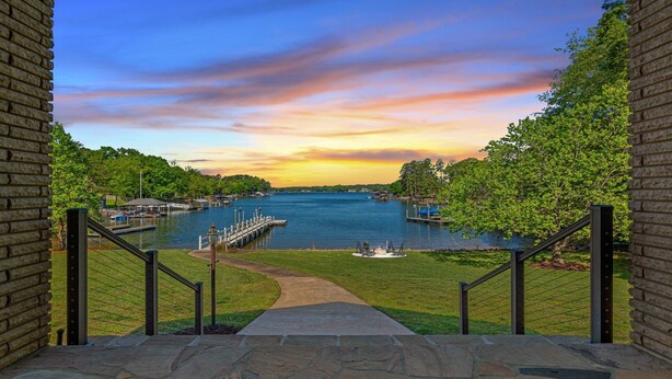 A stone staircase leading to a deck overlooking a lake with docks and a gazebo.