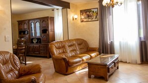 Una sala de estar con un sofá de cuero, una mesa de centro de vidrio y un mueble de madera.