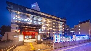 Un hotel de varios pisos con un llamativo letrero que dice 'HOTEL JAPANESQUE'.