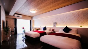 Habitación de hotel con dos camas, techo de madera, aire acondicionado montado en la pared, una mesita con un florero y un ventanal grande.
