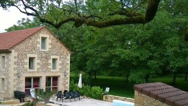 A stone building with a red roof, a swimming pool, and outdoor seating. - Spacious house with private pool and pets allowed (Cénac-et-Saint-Julien)